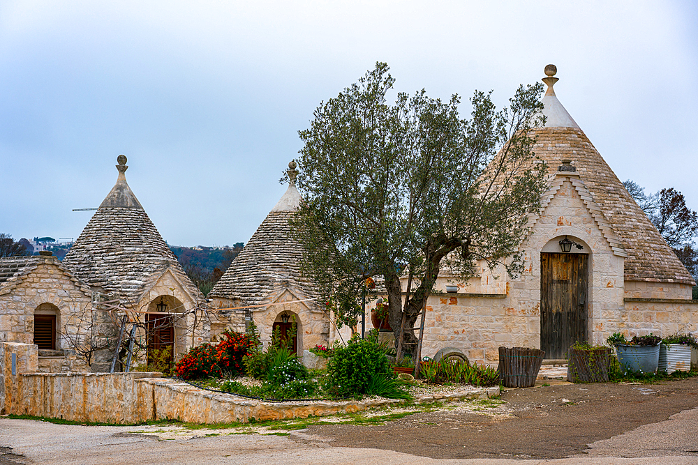 Iconic old Trullo and Trulli white houses with stone ceilings in conic shape, in Italy