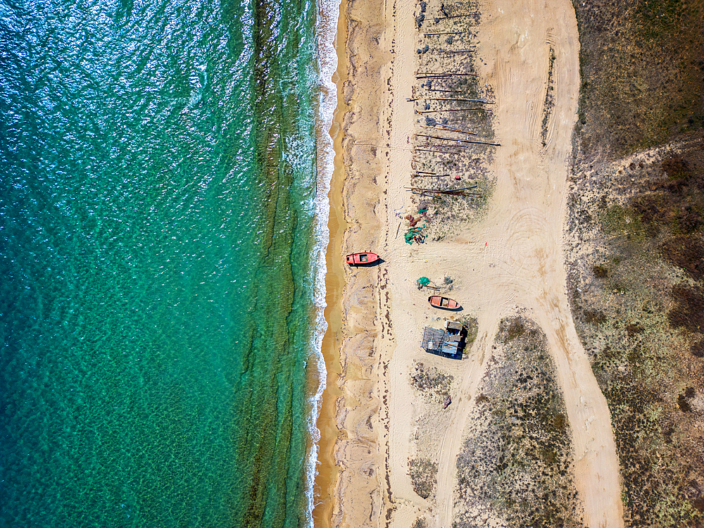 Fishermen boats on a wild beach drone aerial top view