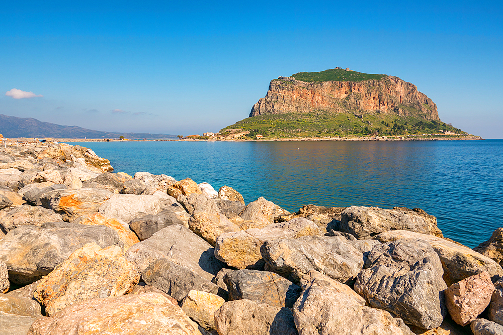 Monemvasia historic city on an island with a mountain in the middle of turquoise sea water, in Greece