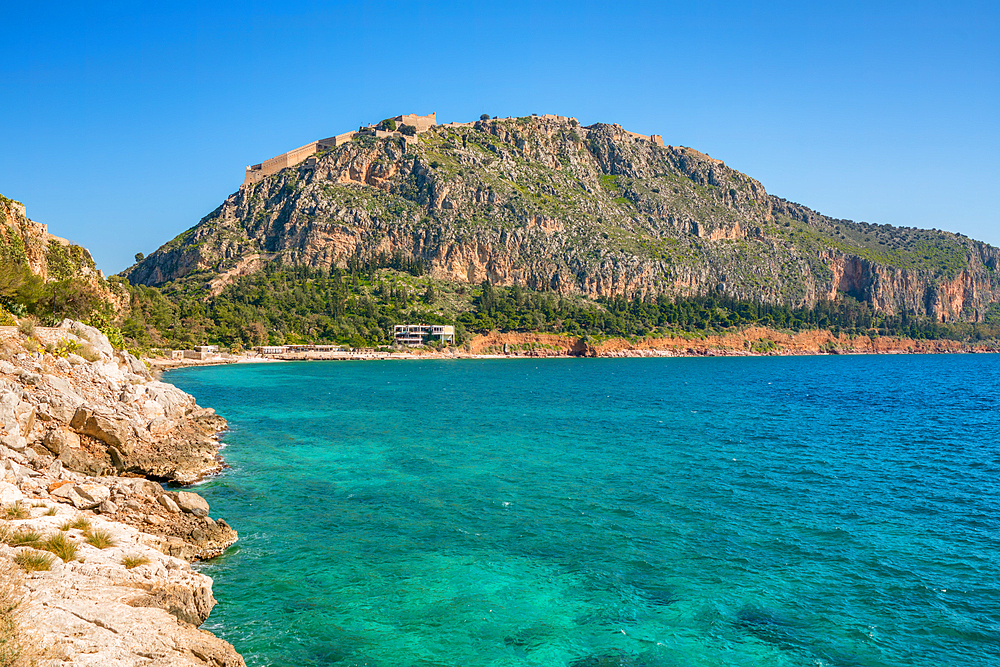 Arvanitias beach in historic city of Nafplion with Palamidi fortress on top of the mountain in Greece