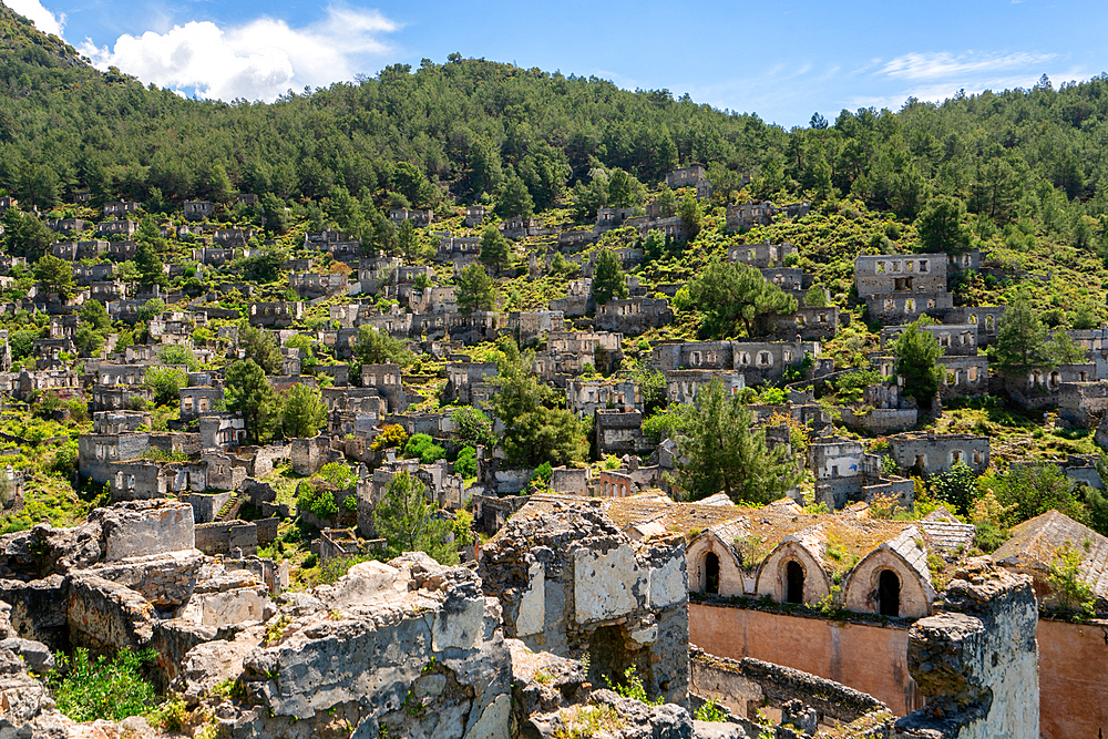 Kayakoy greek ghost town church and abandoned houses in the mountains full of vegetations in Fethiye, Turkey