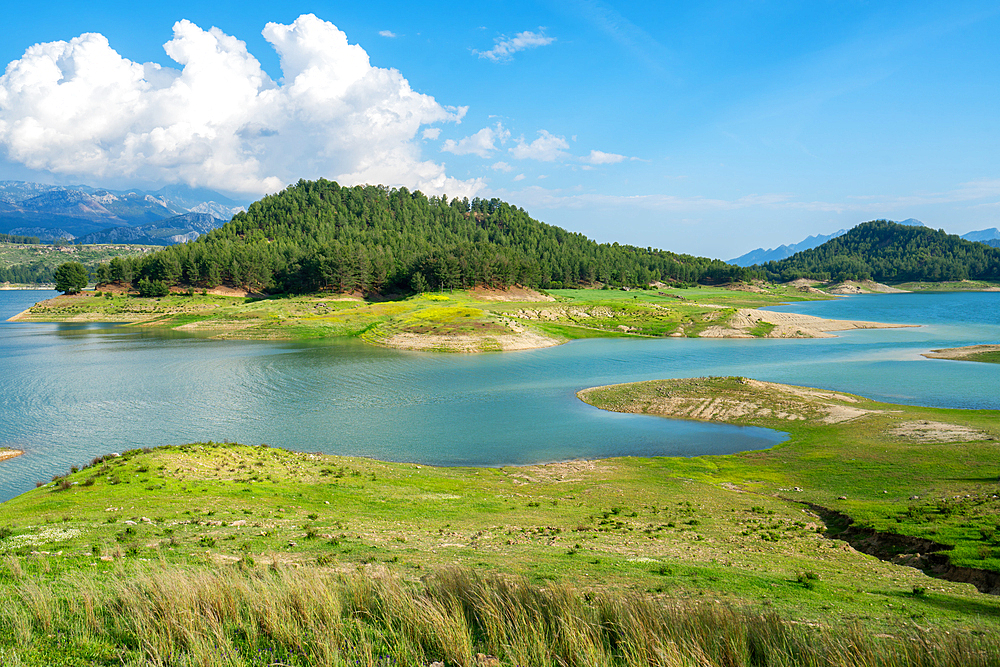 Karacaoren dam lake with turquoise water, trees and mountains on the background on a sunny day in Turkey