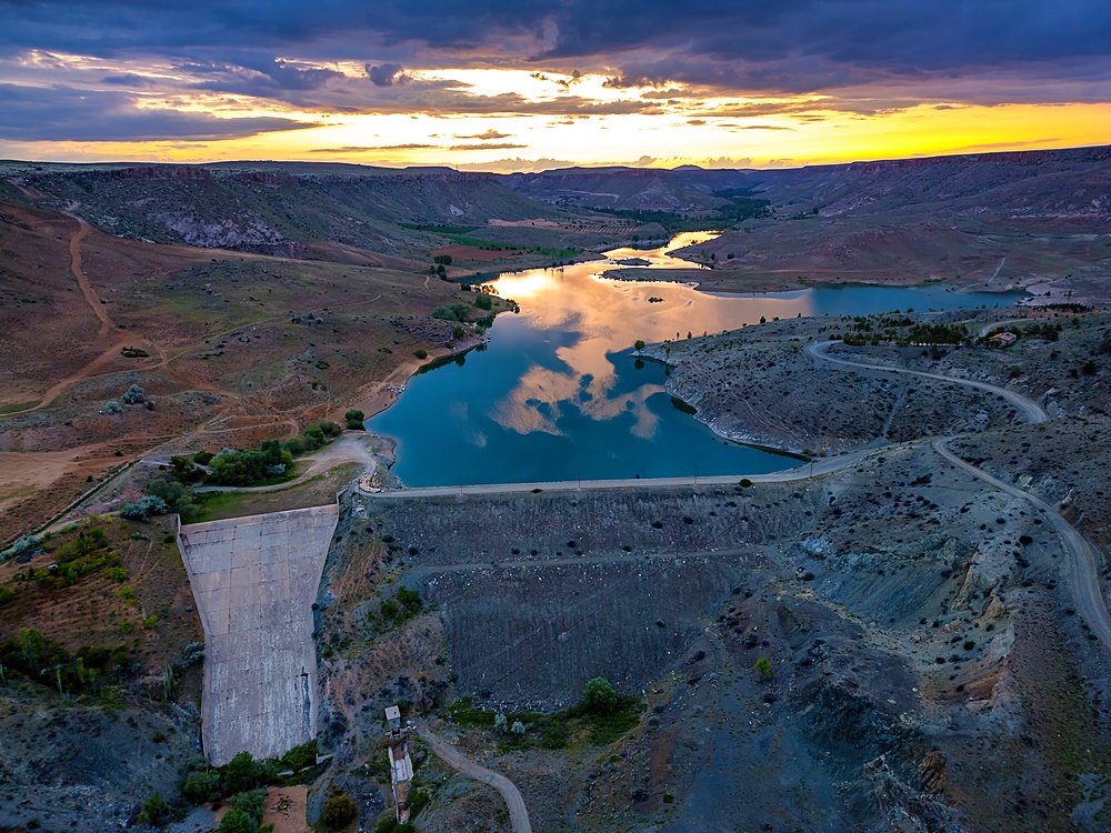 Drone aerial view of Akkoy dam lake with reflection on the water in Cappadocia at sunset, in Turkey