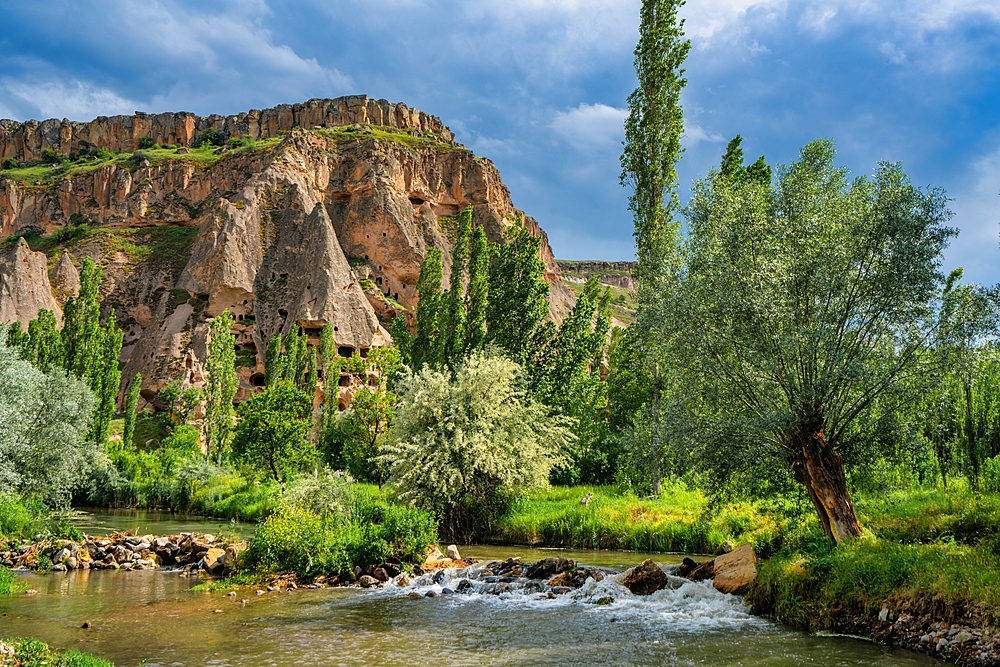 Selime houses carved on the rocks by the river on the Ihlara valley in Cappadocia, Turkey
