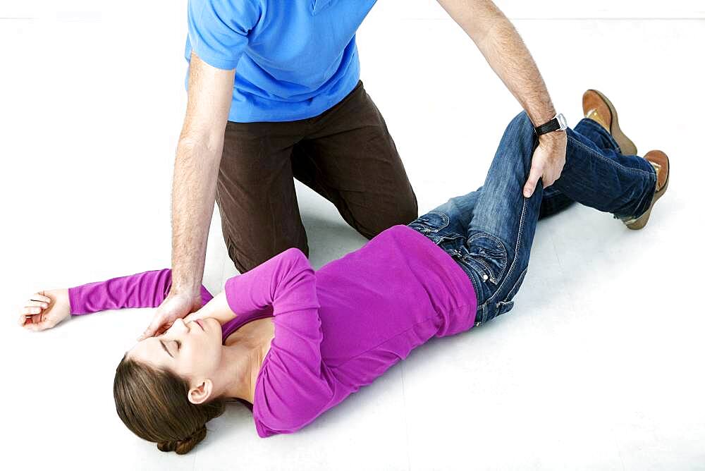 First aid techniques : placing the victim in the recovery position. Step 3 : catch hold of the leg furthest away from you behind the knee, lift it up keeping the foot on the ground. Turn the victim towards you.