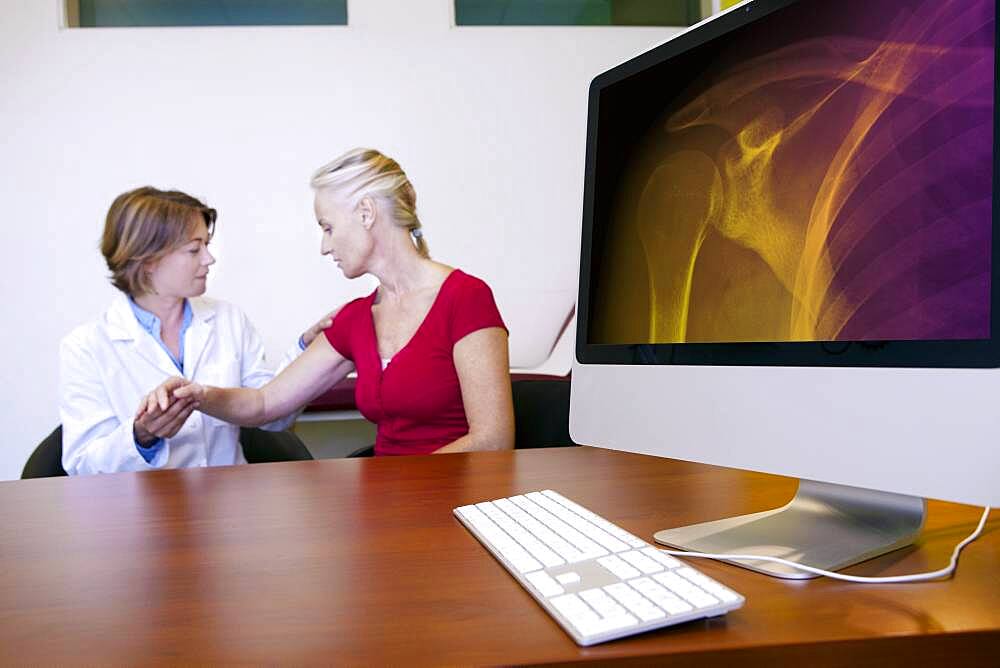 Doctor examining patient's shoulder.