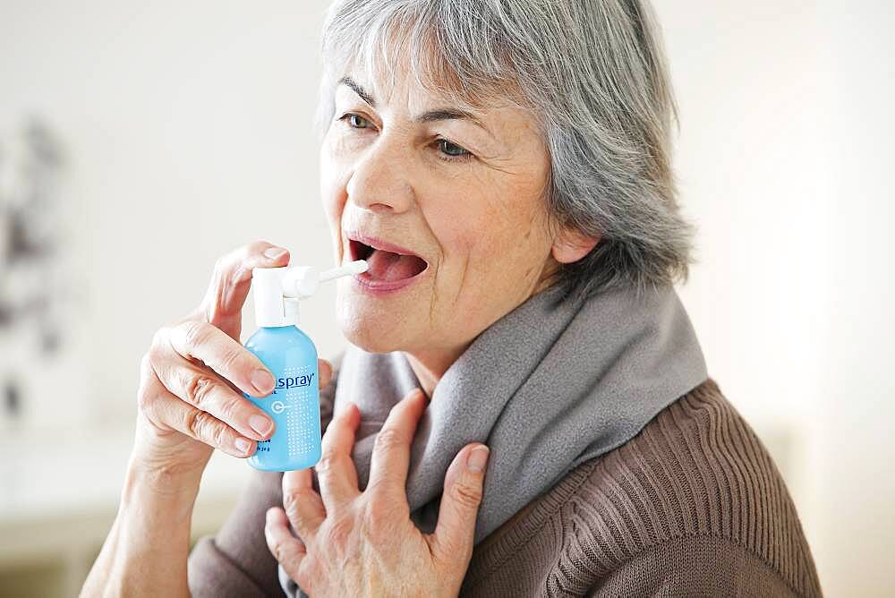 Elderly person using mouth spray