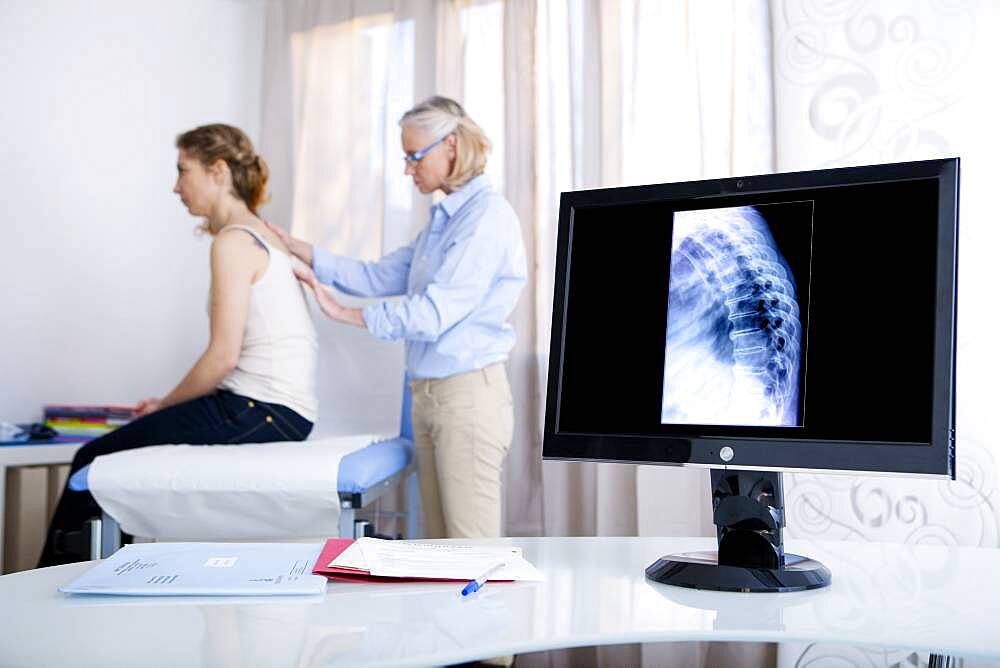 Doctor examining patient's back.