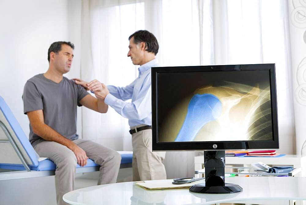 Doctor examining patient's shoulder.