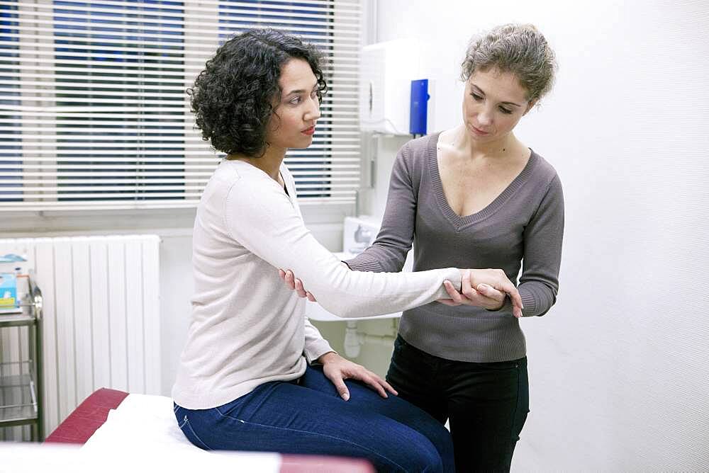 Doctor examining patient's elbow.