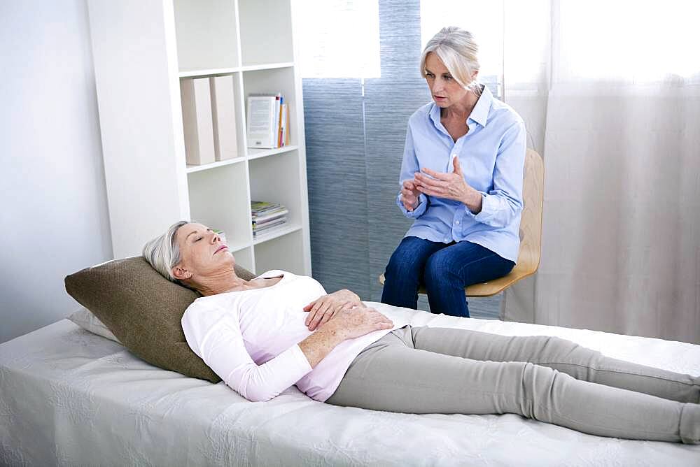 Senior woman undergoing hypnosis session.