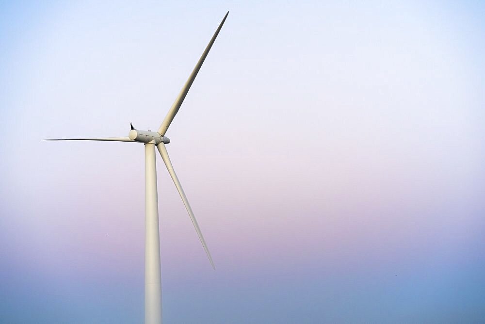 Commercial wind turbine in the early morning fog at sunrise in the English countryside