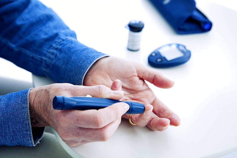 Senior woman checking her blood glucose level.