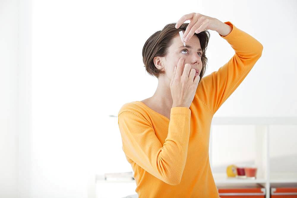 Woman using eye lotion