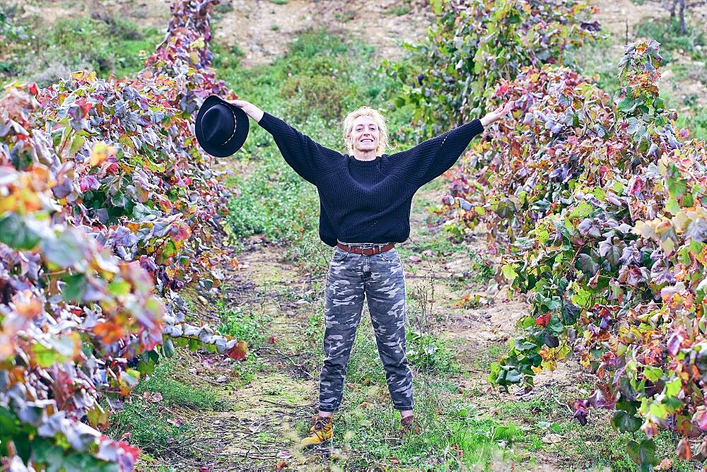 Mature young blondy farmer woman in a farmland with vineyards. Iguzkiza, Navarre, Spain, Europe.