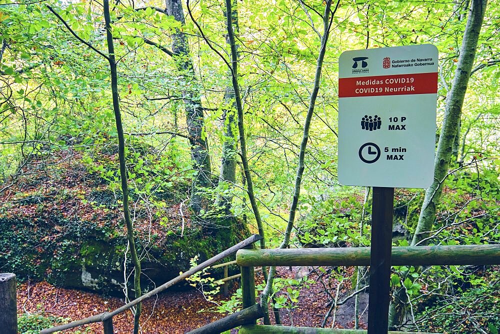 Signal with COVID 19 precautionary measures in a nature place. Urederra river source. Urbasa-Andia Natural Park. Navarre, Spain, Europe.