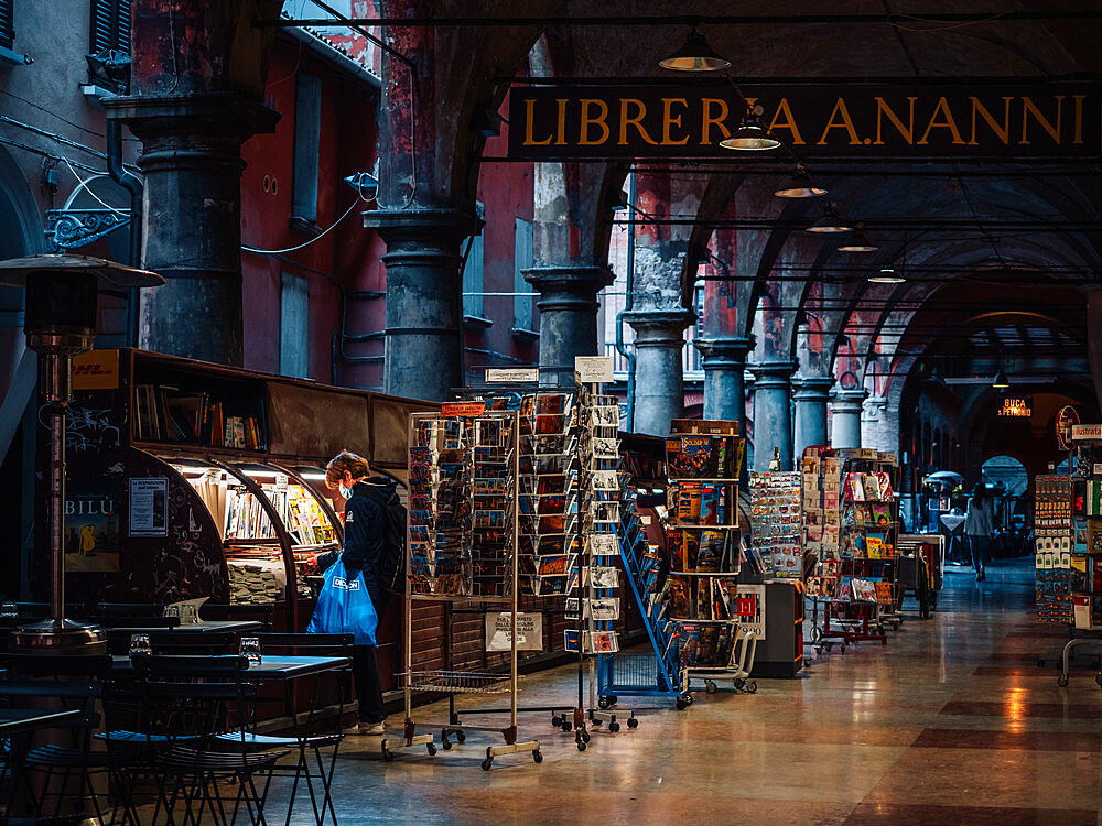 Via De' Musei in Bologna's old town center with a person looking at books in a bookstore, Bologna, Emilia Romagna, Italy, Europe