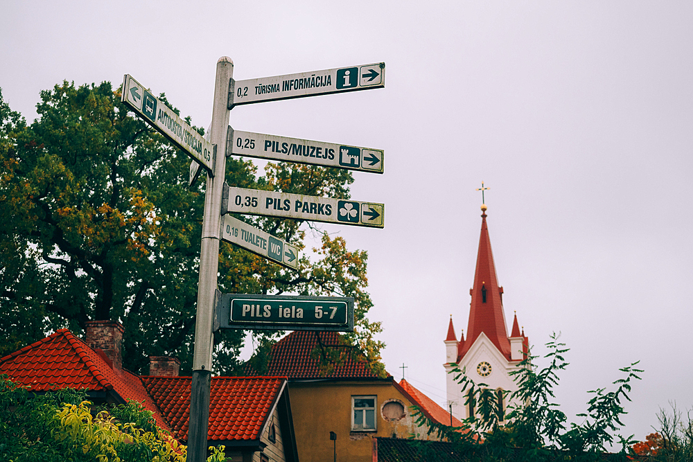 Signpost and St. John's Church in the Medieval Cesis Old Town, Cesis, Latvia, Baltics, Europe