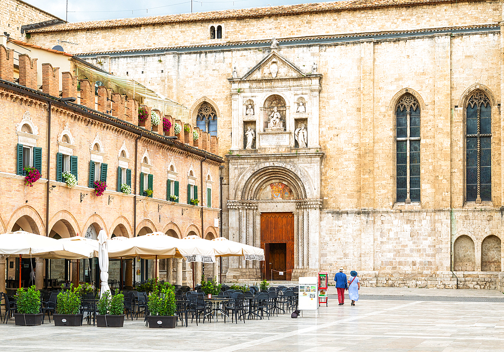 A couple walking towards the Church of San Francesco (the Basilica di San Francesco) in Piazza del Popolo, Ascoli Piceno, Marche, Italy