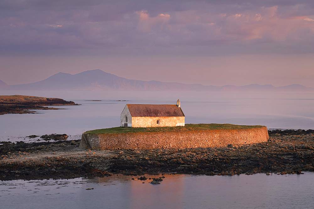 Evening Light illluminates St. Cwyfan's Church (Church in the Sea) on the island of Cribinau backed by the Lleyn peninsula, near Aberffraw, Anglesey, North Wales, United Kingdom, Europe