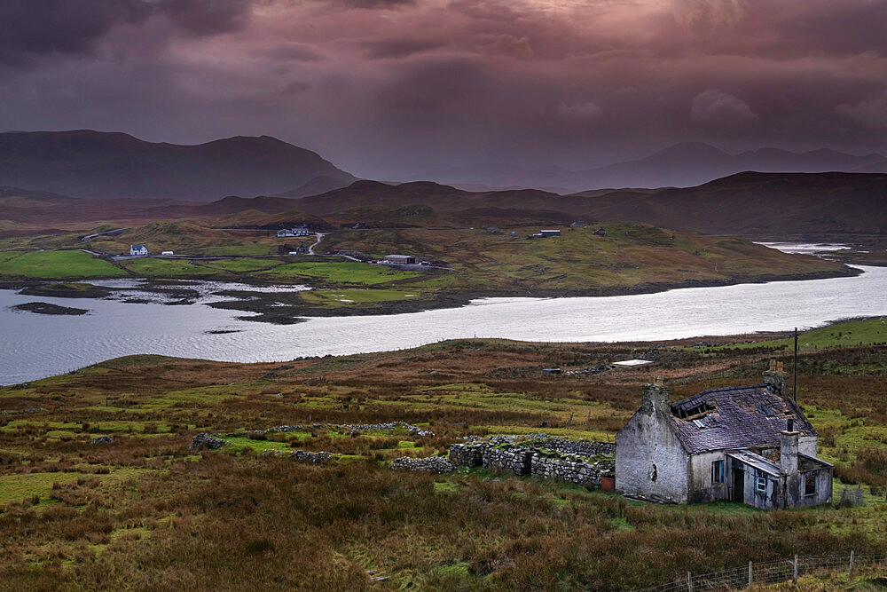 Abandoned Croft backed by Loch Eireasort and the Harris Hills, near Baile Ailein, Isle of Lewis, Outer Hebrides, Scotland, United Kingdom, Europe