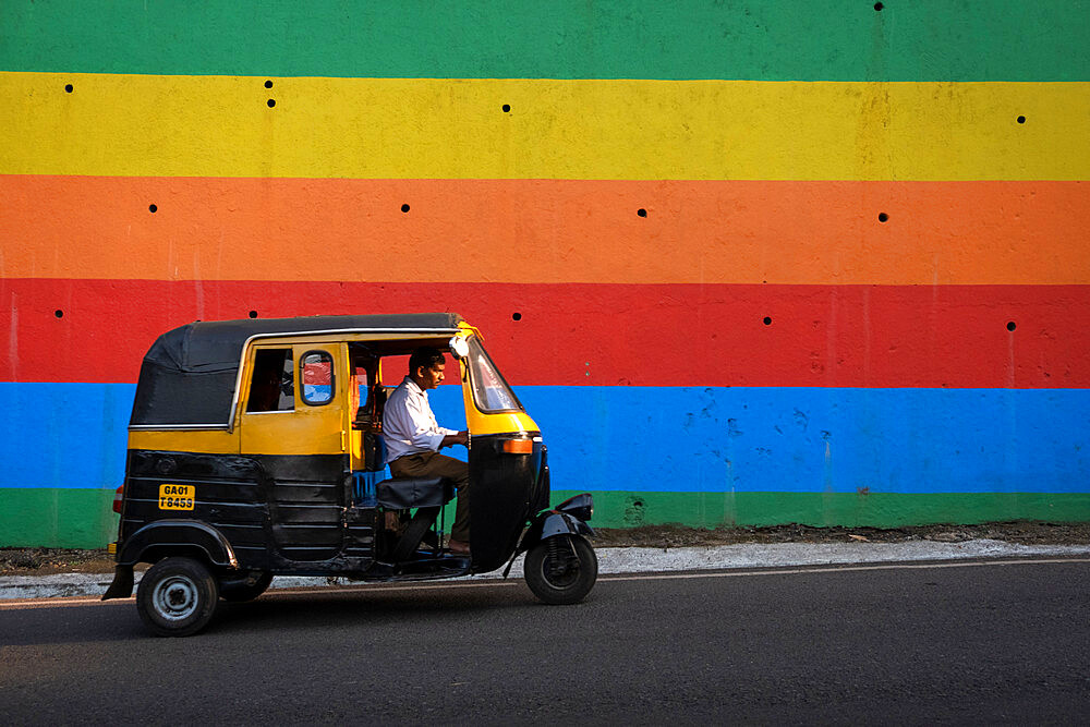 Indian Tuk Tuk passing a brightly painted wall in Panjim City, Panjim (Panaji), Goa, India, Asia