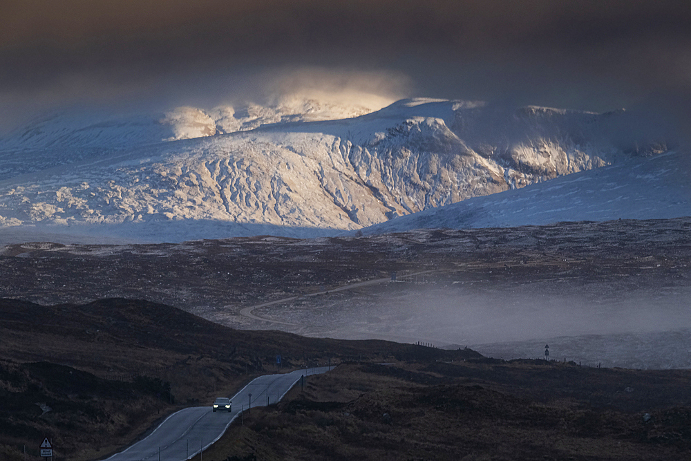 Single car crossing Rannoch Moor on the A82 Trunk Road at dusk with Beinn a Chreachain and the Grampian Mountains behind, Rannoch Moor, Argyll and Bute, Scottish Highlands, Scotland, United Kingdom, Europe