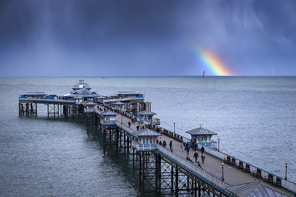 Rainbow and moody skies over Llandudno Pier, Llandudno, Conwy County Borough, North Wales, United Kingdom, Europe