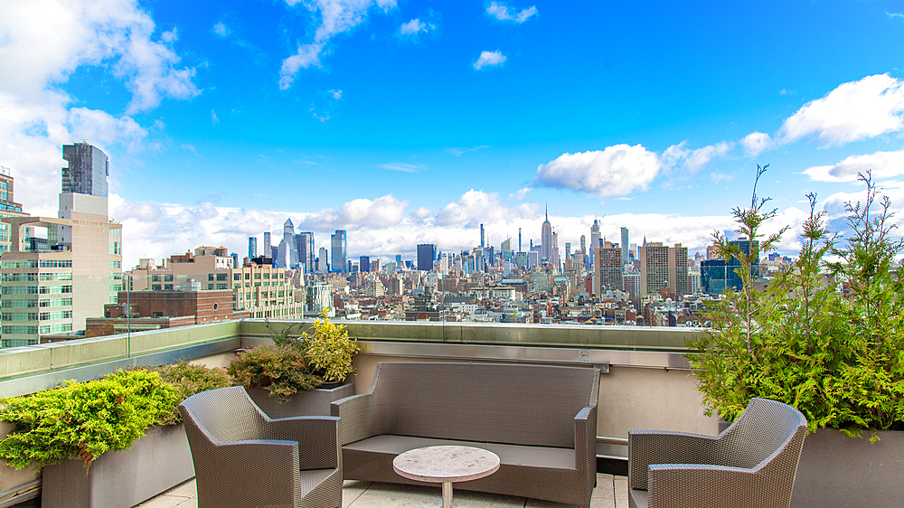 Roof top bar in Tribeca, New York City, USA, looking North towards Midtown and the Empire State Building.