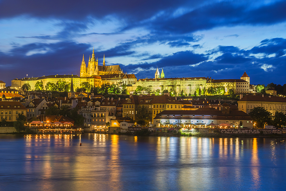 Illuminated Prague Castle rising above Vltava River at twilight, UNESCO World Heritage Site, Prague, Czech Republic (Czechia), Europe