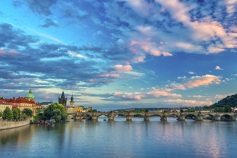 Charles Bridge, OId Town Bridge Tower and dome of St. Francis of Assisi Church by Vltava River at sunset, UNESCO World Heritage Site, Prague, Czech Republic (Czechia), Europe