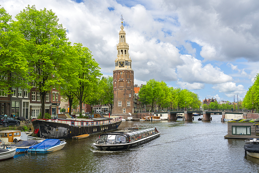 Boat on Rapenburgwal canal and Montelbaanstoren tower in the background, Amsterdam, The Netherlands, Europe