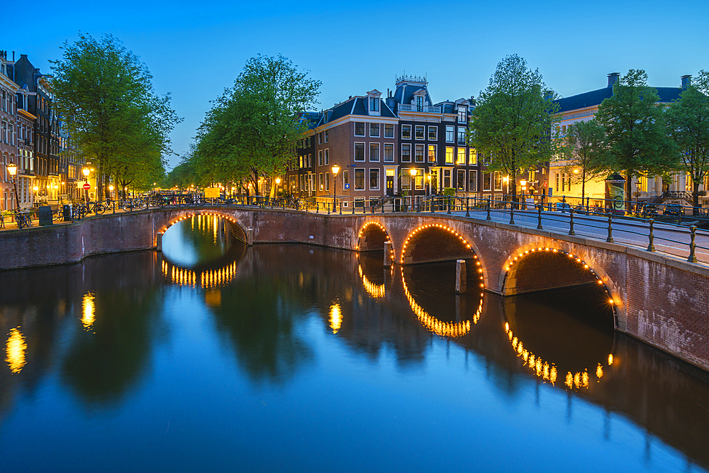 Illuminated bridge over Keizersgracht canal at twilight, Amsterdam, The Netherlands, Europe