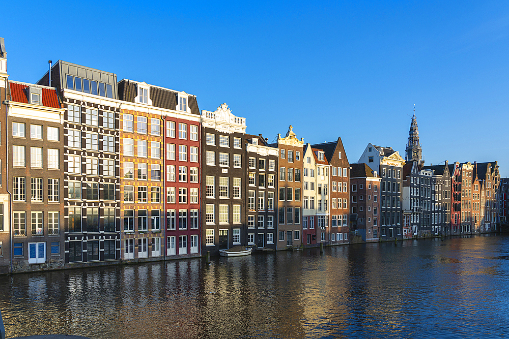 Dancing houses at Damrak and tower of Oude Kerk Amsterdam Church at sunset, Amsterdam, The Netherlands, Europe