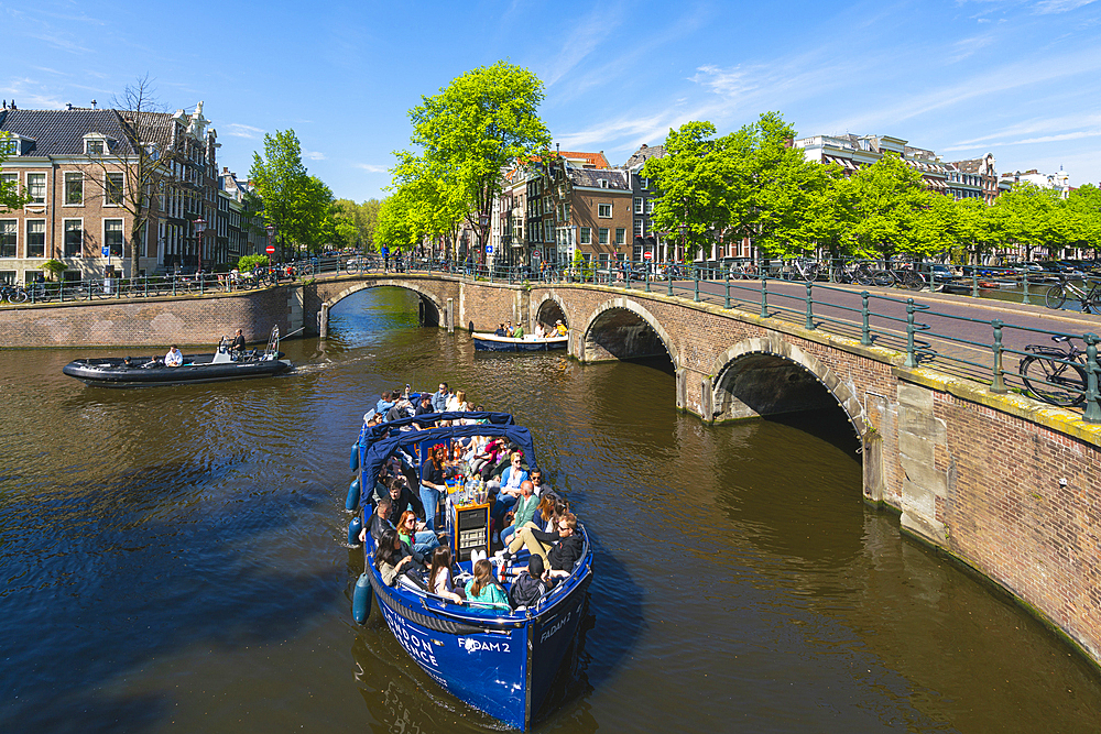 Tourist boats at intersection of Keizersgracht and Reguliersgracht canals, Amsterdam, The Netherlands, Europe