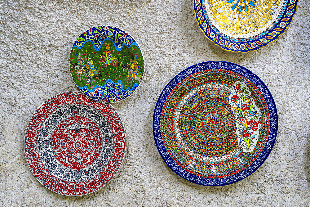 Colorful ceramic plates on display on wall inside ceramic store, Avanos, Cappadocia, Central Anatolia Region, Anatolia, Turkey, Asia Minor, Asia