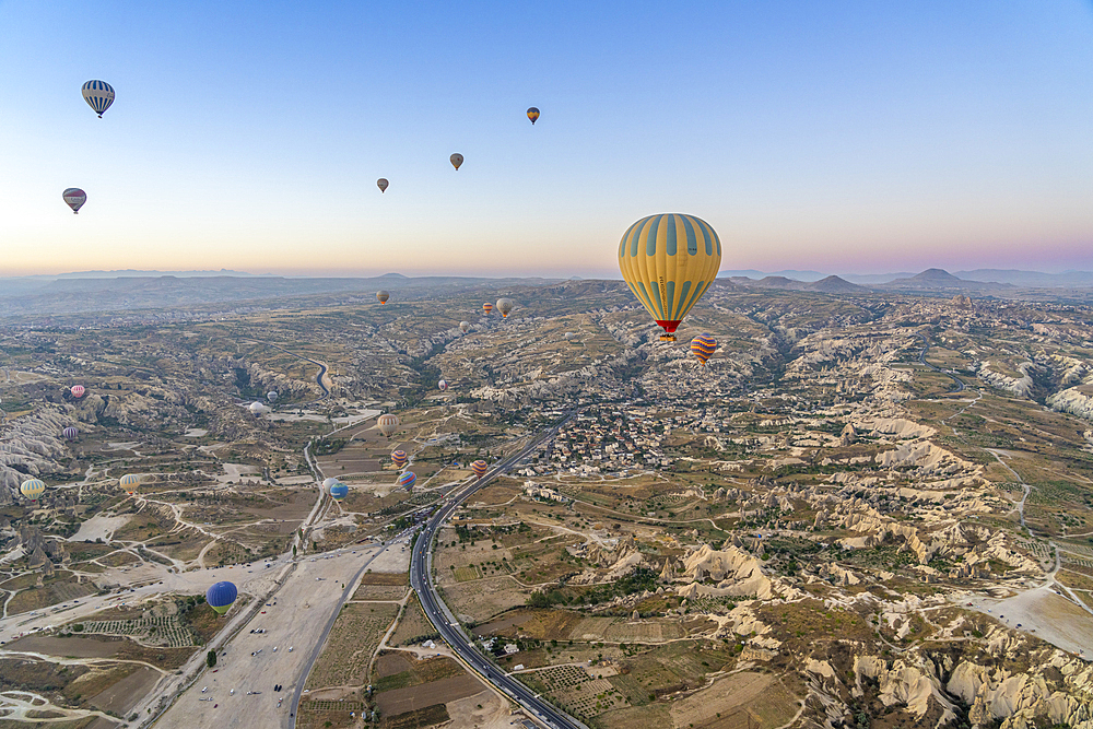 Aerial view of Cavusin and hot air balloons at dawn, Avanos District, Nevsehir Province, Cappadocia, Central Anatolia Region, Anatolia, Turkey, Asia Minor, Asia