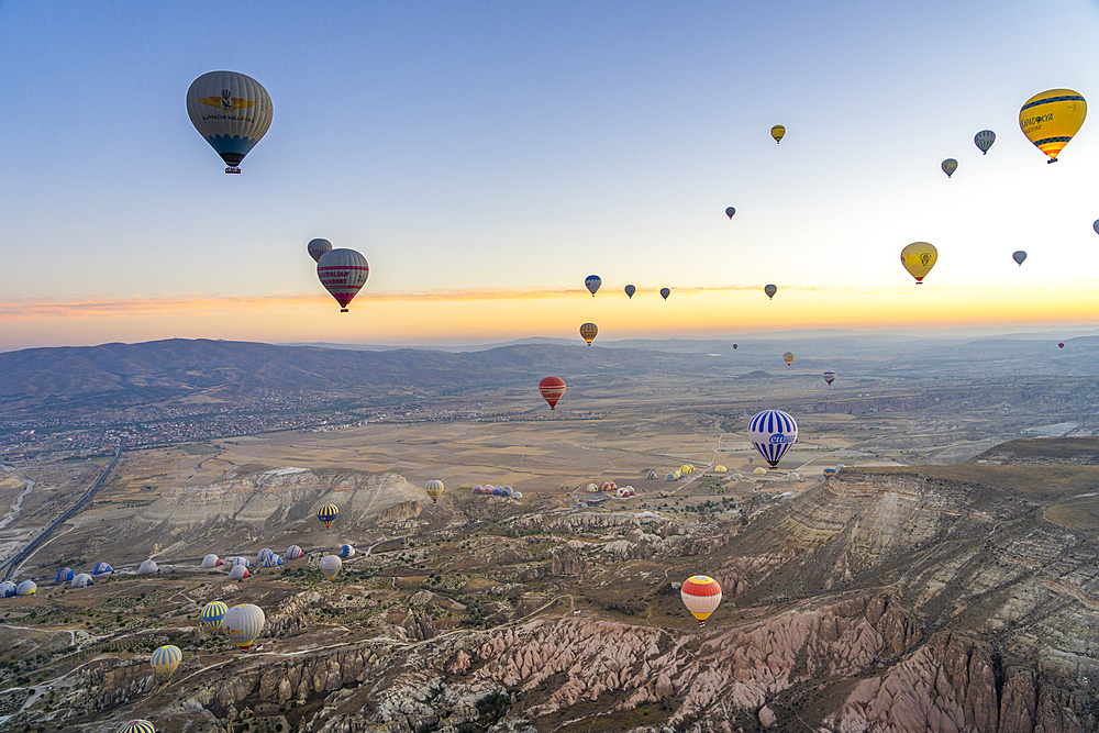 Aerial view of Cavusin and hot air balloons at dawn, Avanos District, Nevsehir Province, Cappadocia, Central Anatolia Region, Anatolia, Turkey, Asia Minor, Asia