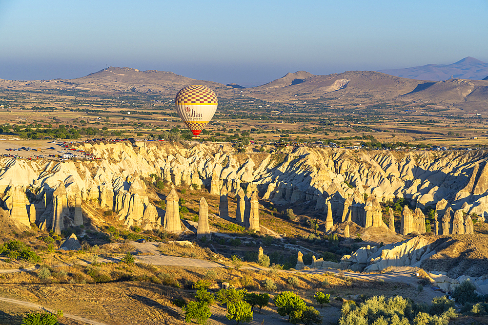 Aerial view of hot air balloon over rock formations in Love Valley at sunrise, Goreme, Goreme Historical National Park, UNESCO World Heritage Site, Cappadocia, Central Anatolia Region, Anatolia, Turkey, Asia Minor, Asia