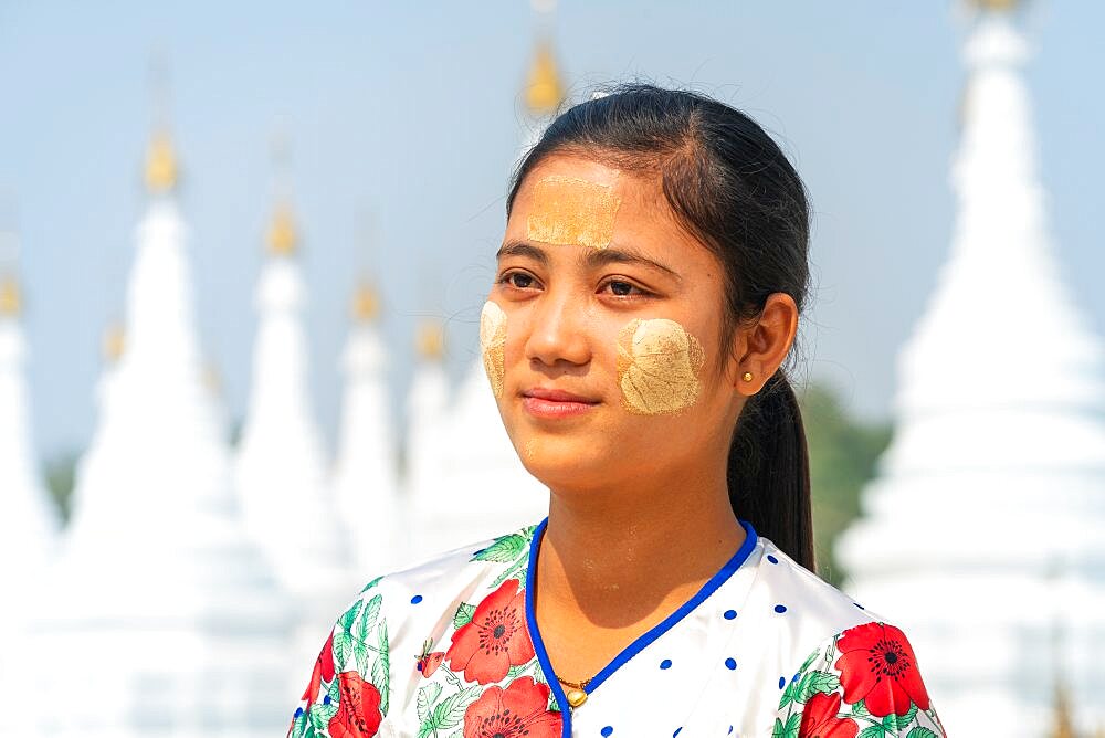 Young Burmese woman at white stupas of Sanda Muni Pagoda (AKA Sanda Mu Ni, Sandamani and Sandamuni), Mandalay, Myanmar