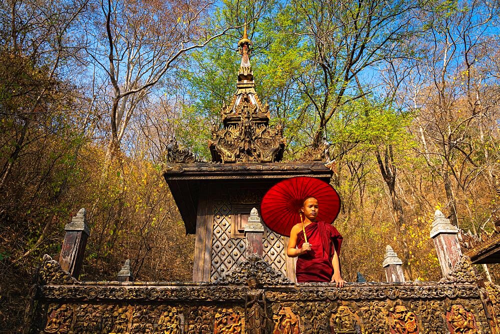 Novice monk with umbrella at monastery, Mandalay, Myanmar