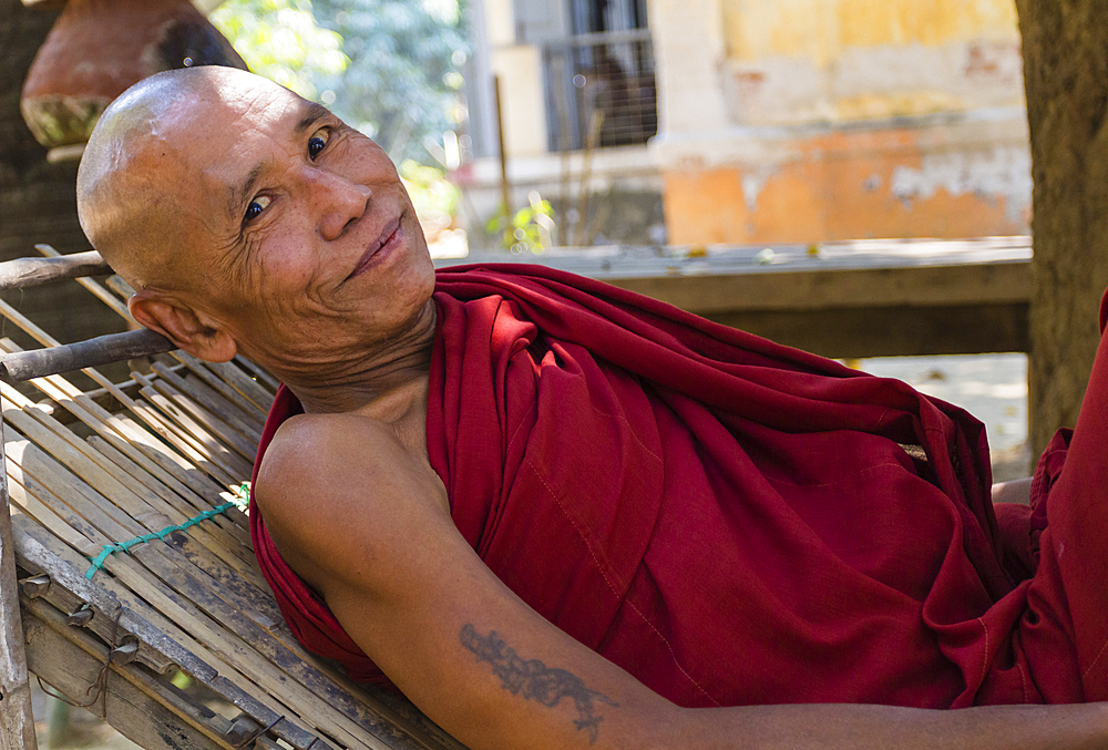 Senior monk resting on reclining chair outside of Shwenandaw Temple, Mandalay, Myanmar (Burma), Asia