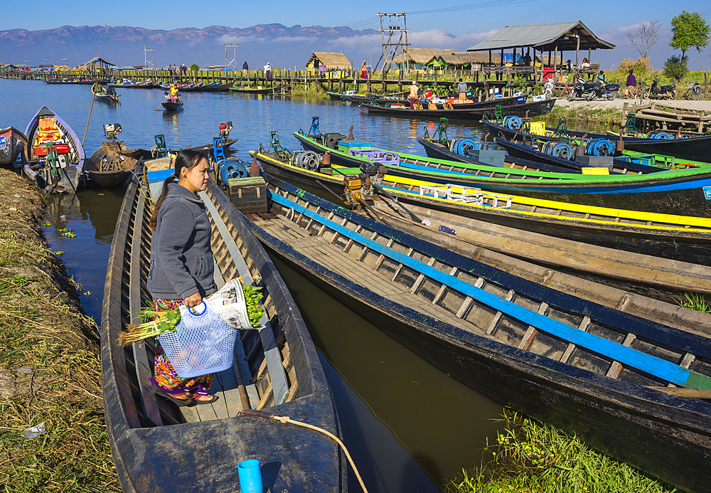 Woman returning to boat after shopping, boat harbor, Lake Inle, Shan State, Myanmar (Burma), Asia