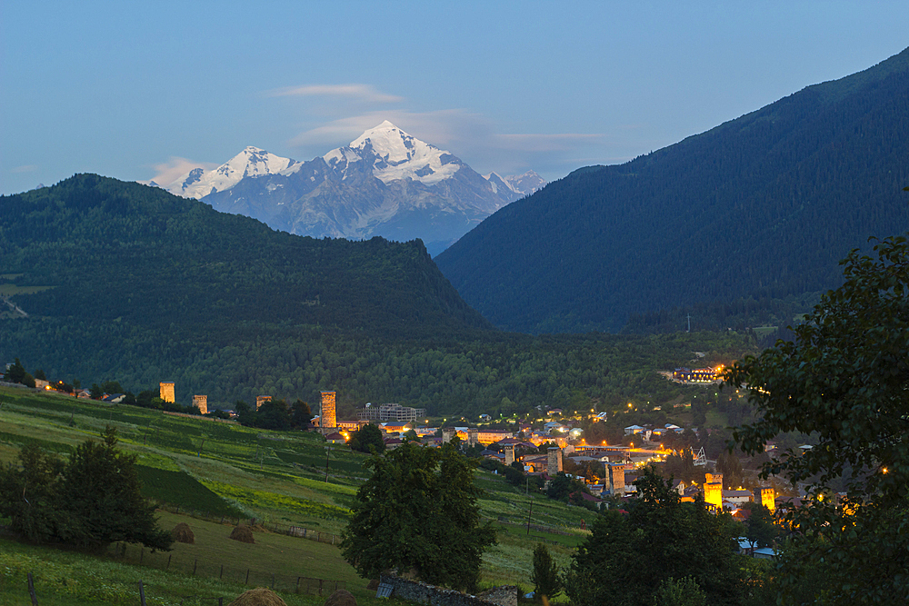 Tetnuldi mountain, 4858 m, rising above Mestia at twilight, Svaneti mountains, Georgia, Central Asia, Asia