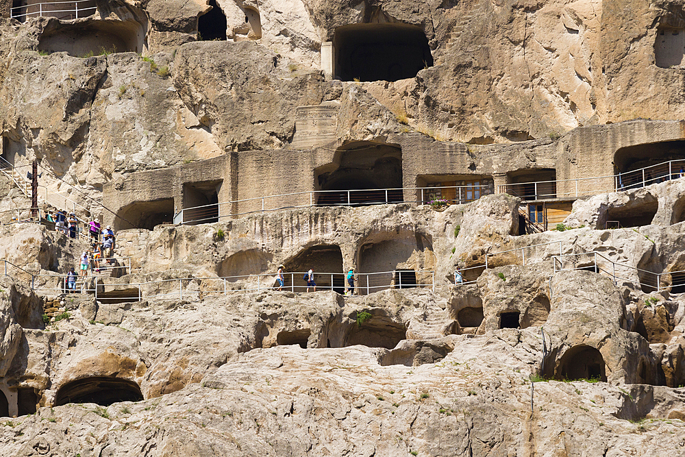 Tourists exploring ancient cave city of Vardzia, Georgia, Central Asia, Asia