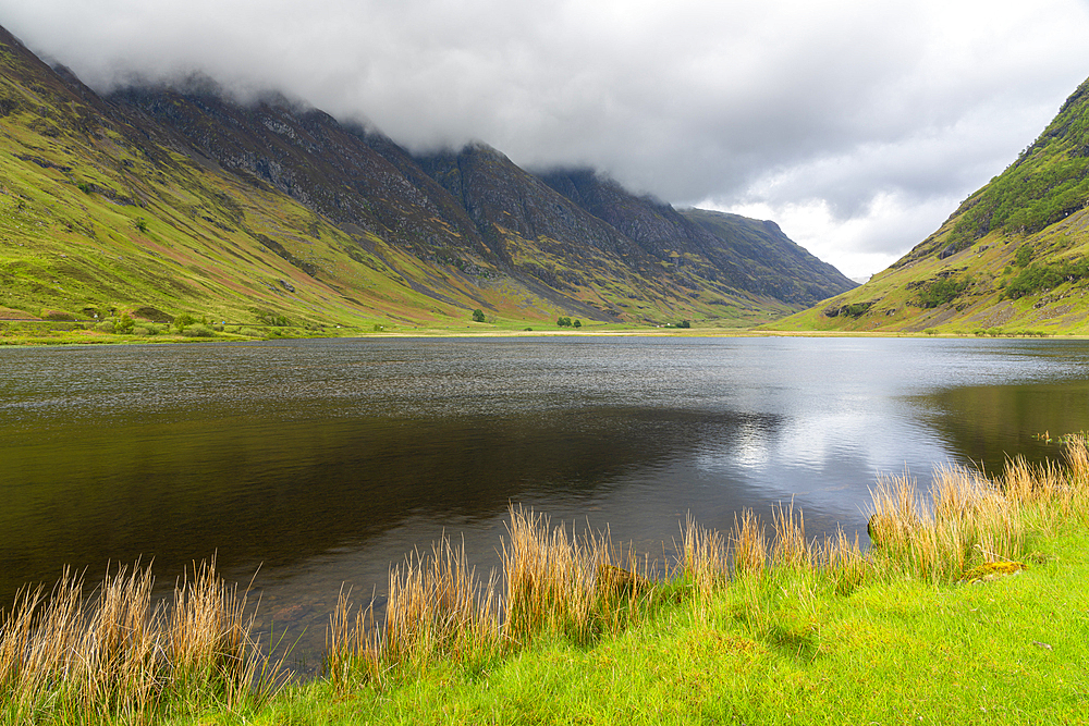 Loch Achtriochtan in valley against cloudy sky, Glencoe, Scottish Highlands, Scotland, United Kingdom, Europe