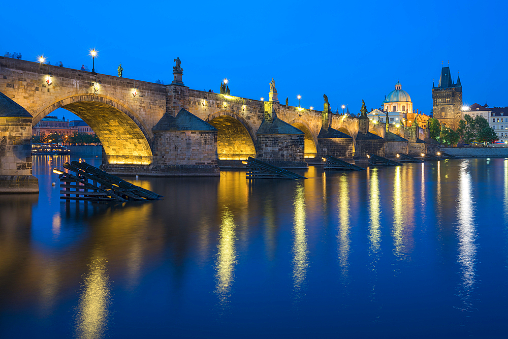 Illuminated Charles Bridge with reflections at twilight, UNESCO World Heritage Site, Prague, Bohemia, Czech Republic (Czechia), Europe