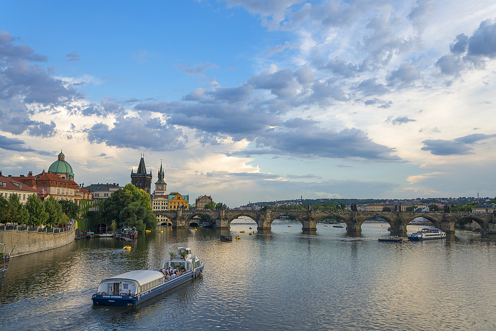 Boat going towards Charles Bridge and Old Town Bridge Tower, UNESCO World Heritage Site, Prague, Bohemia, Czech Republic (Czechia), Europe