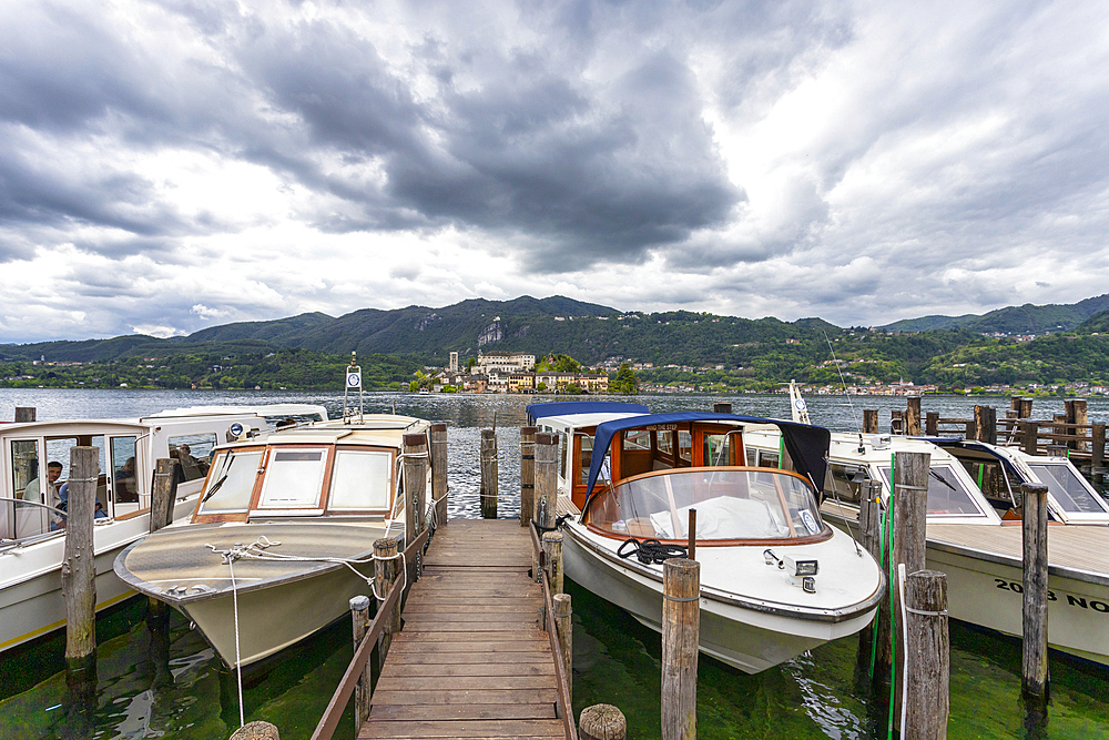 Boats moored in the small port of Orta, and the island of San Giulio in the background, Orta, Novara district, Italian Lakes, Piedmont, Italy, Europe