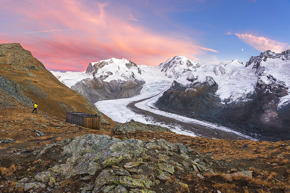 Hiker admiring snow covered peaks of Monte Rosa massif and the Gorner Glacier (Gornergletscher), Gornergrat, Zermatt, Valais Canton, Swiss Alps, Switzerland, Europe